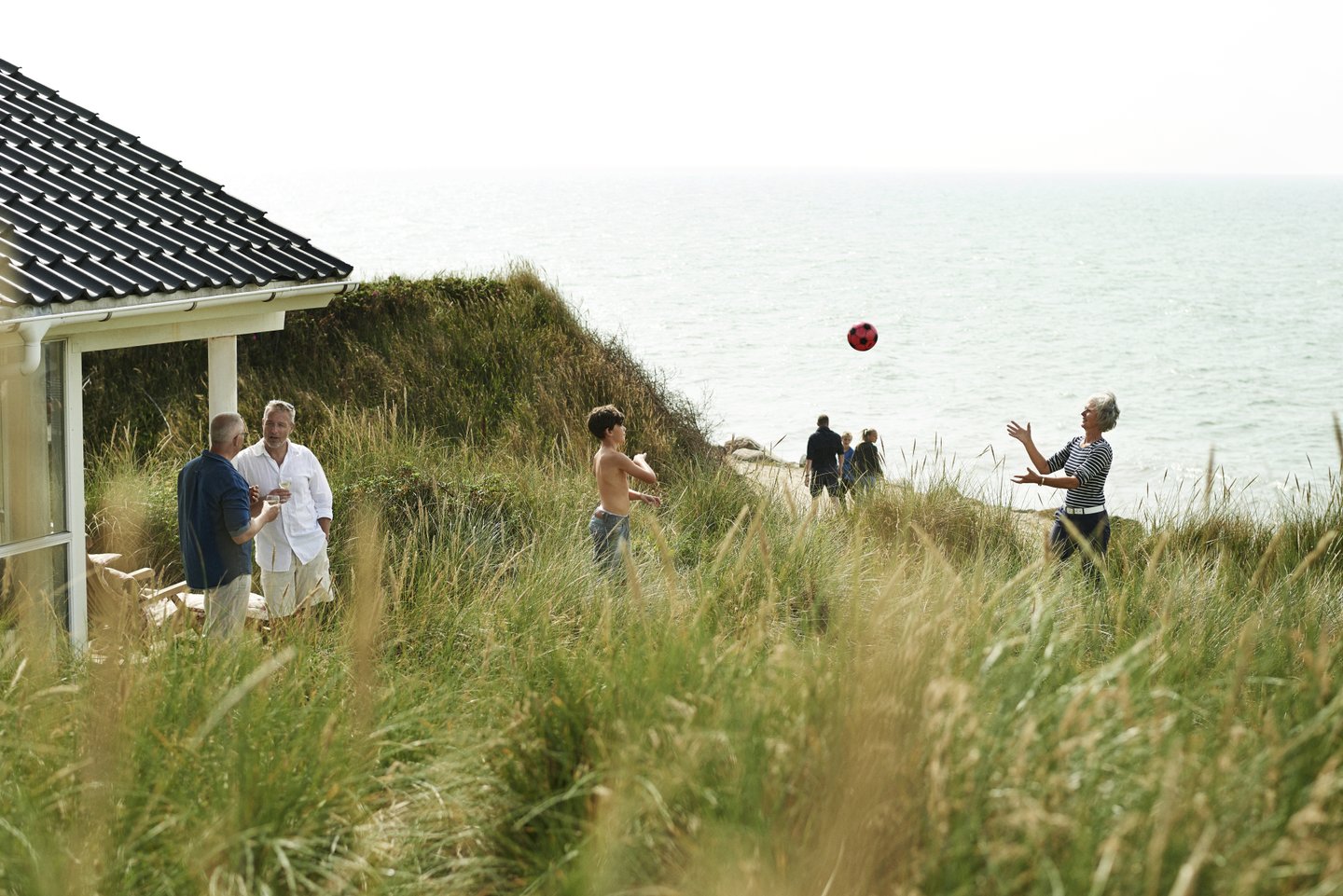 Familie som leker ved feriehuset i Jylland