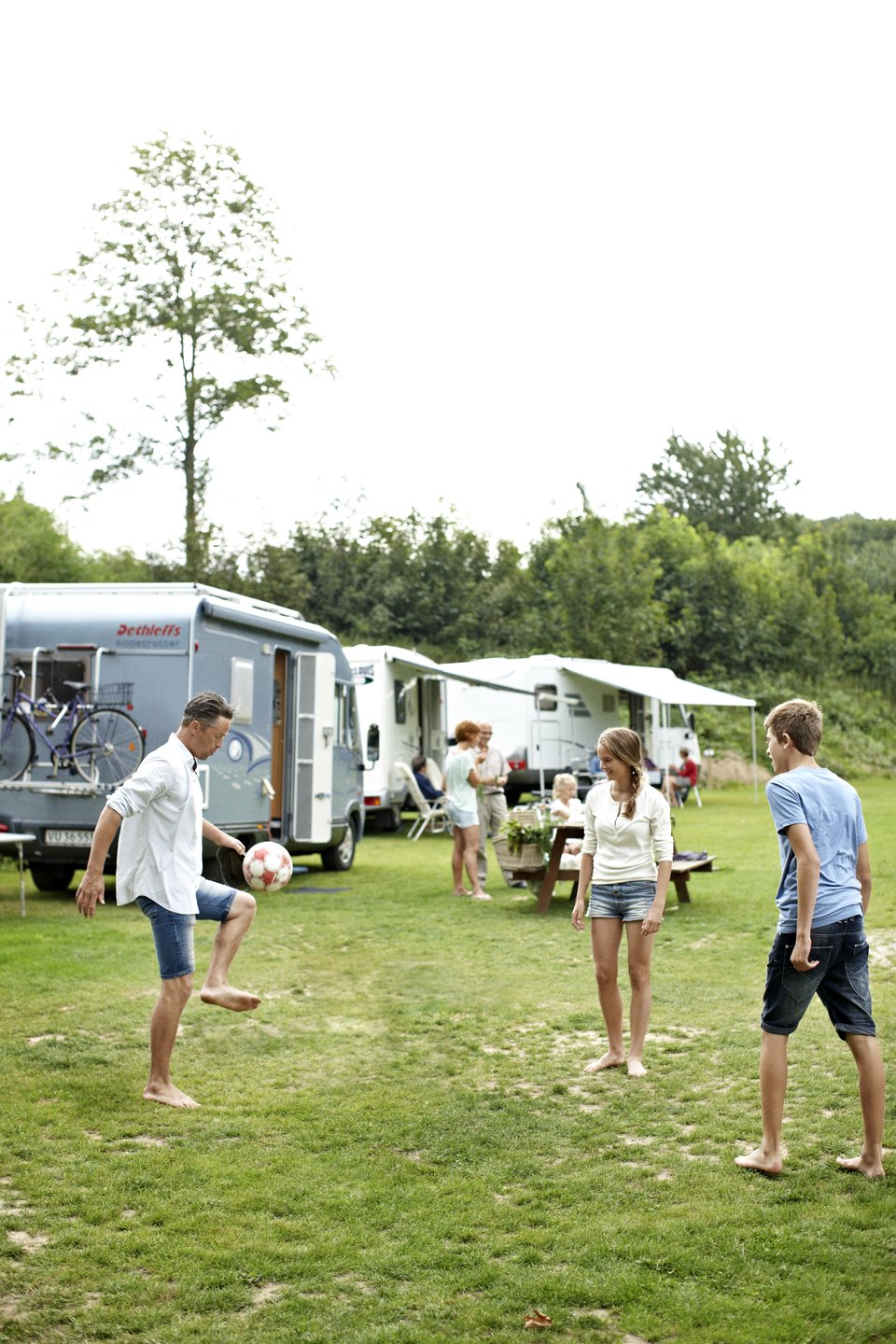 Family playing football at camping site