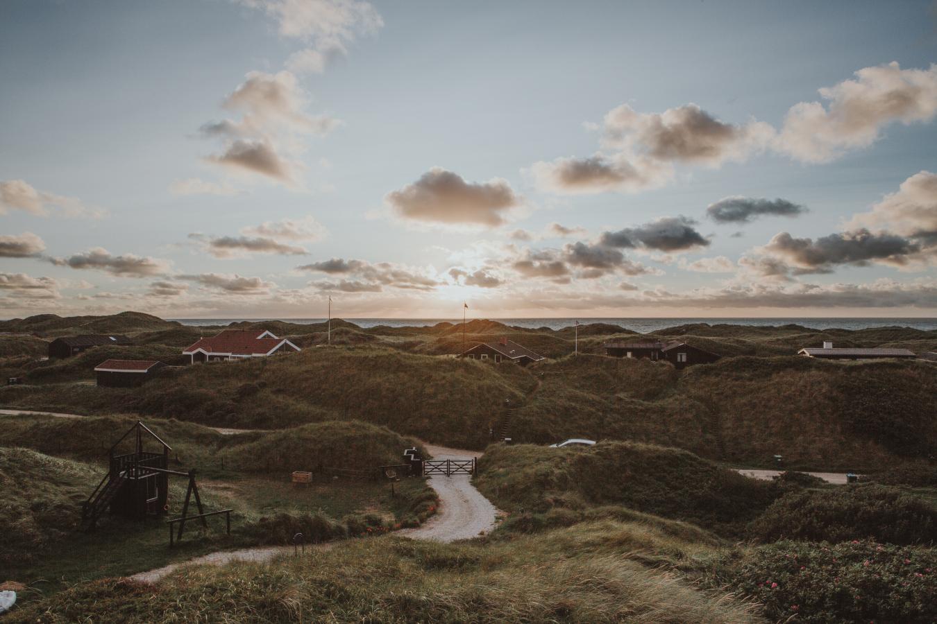 Ferienhäuser bei Sonnenuntergang in den Dünen von Løkken an der Dänischen Nordsee