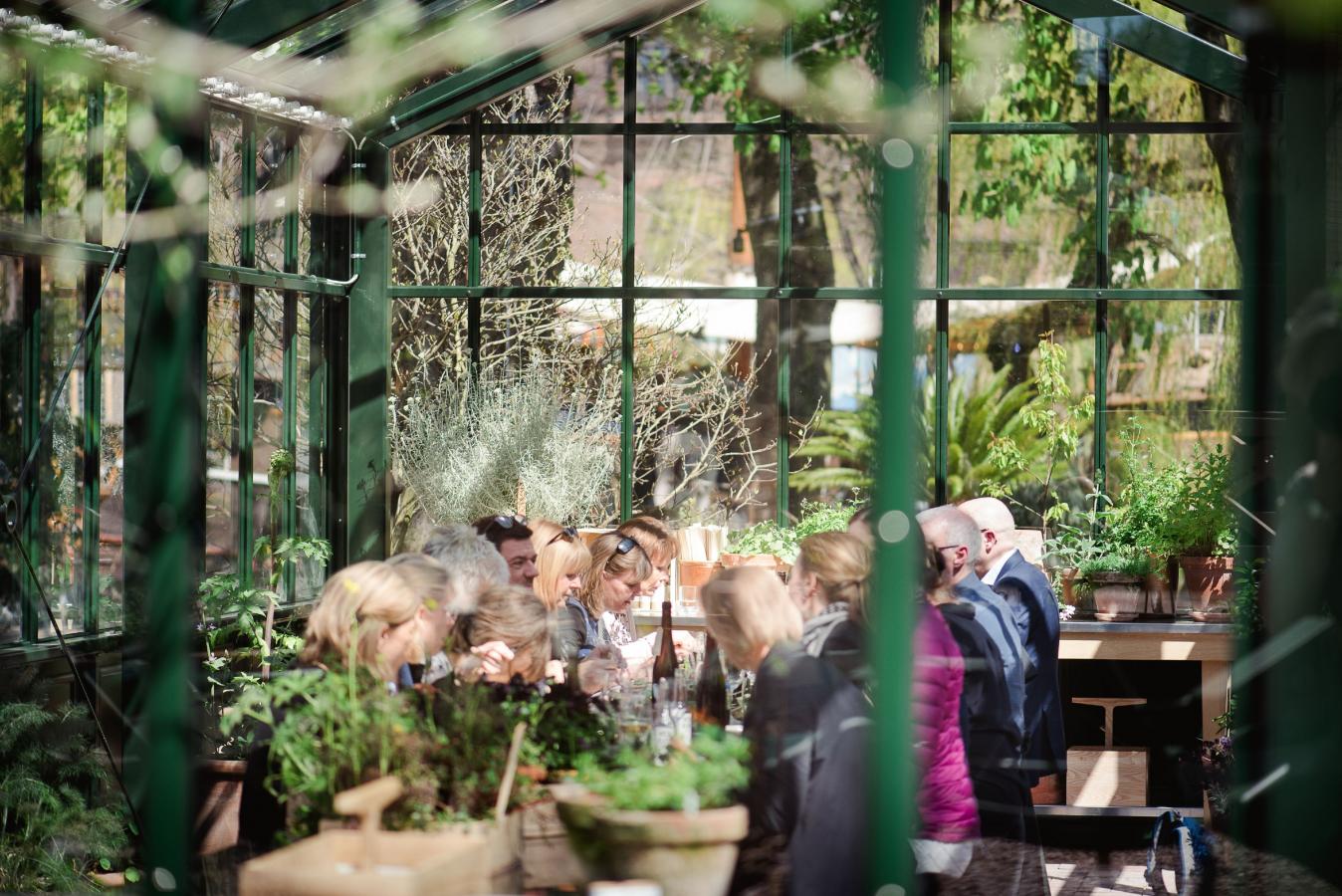 People eating in the greenhouse room at Gemyse Tivoli in Copenhagen