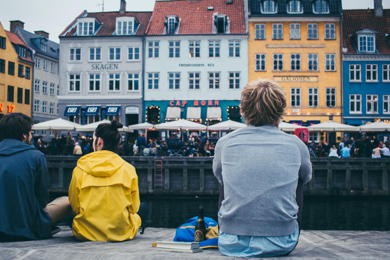 People sitting by the dock in Nyhavn, Copenhagen
