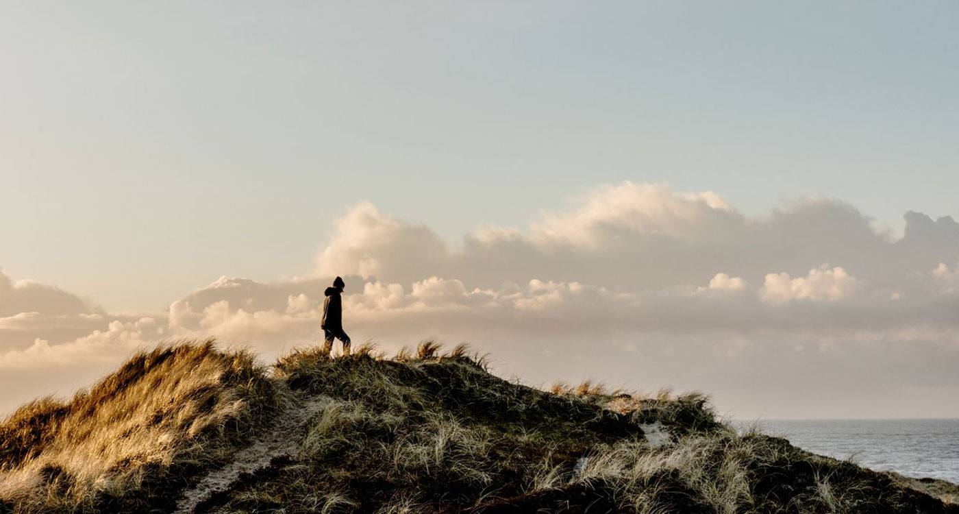 Boy walking on a windy sand dune in Klitmoeller, Thy National Park