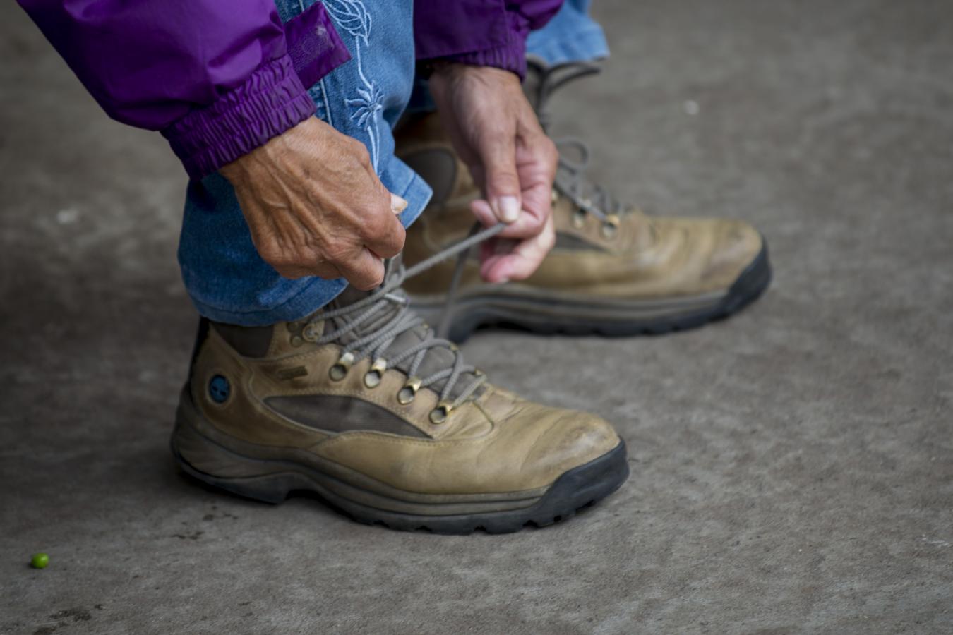 Wanderer schnürt Wanderschuhe auf dem dänischen Pilgerweg Heerweg