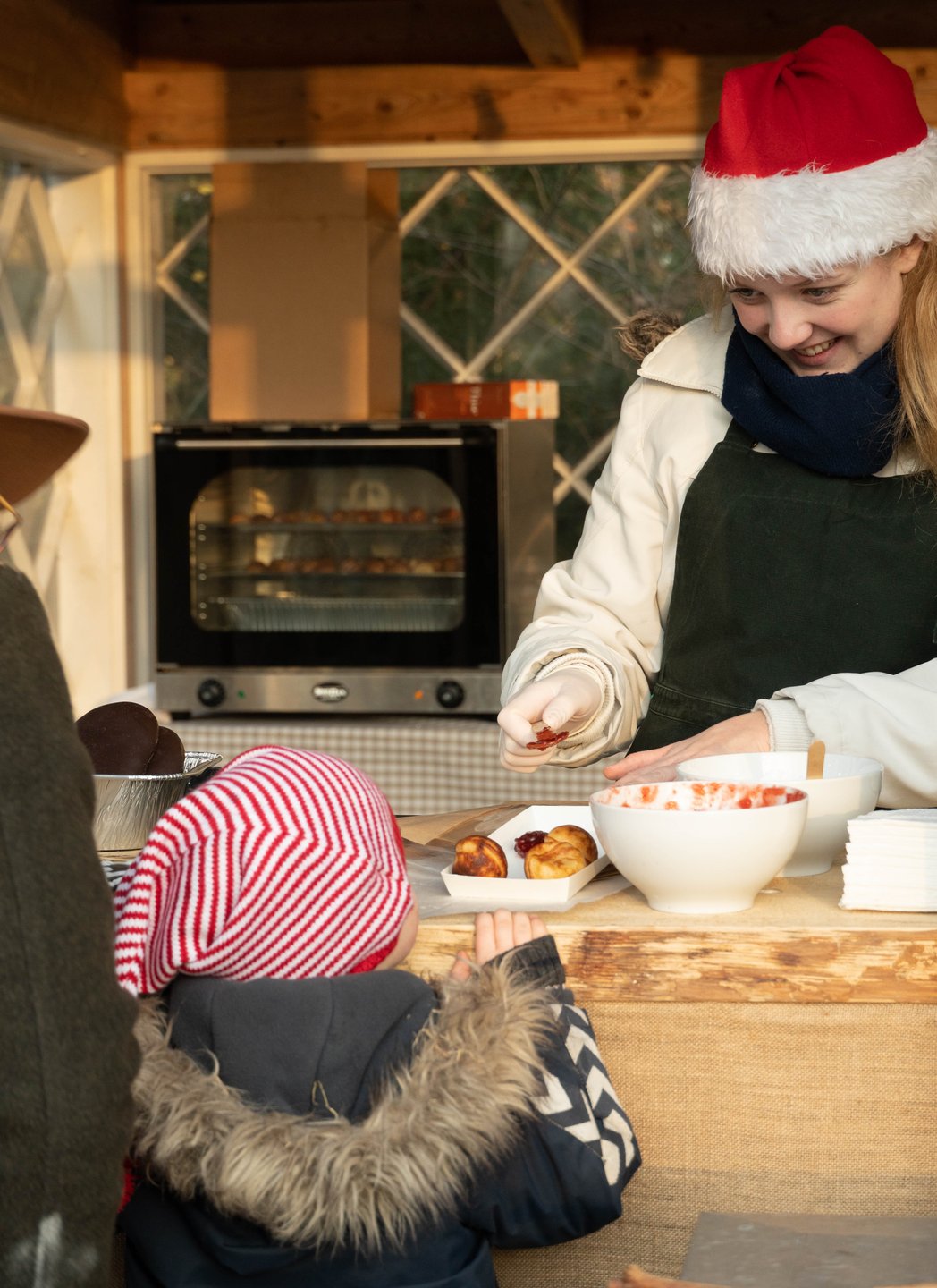 A child buying æbleskiver at a stall at the Open Air Museum in North Sealand.