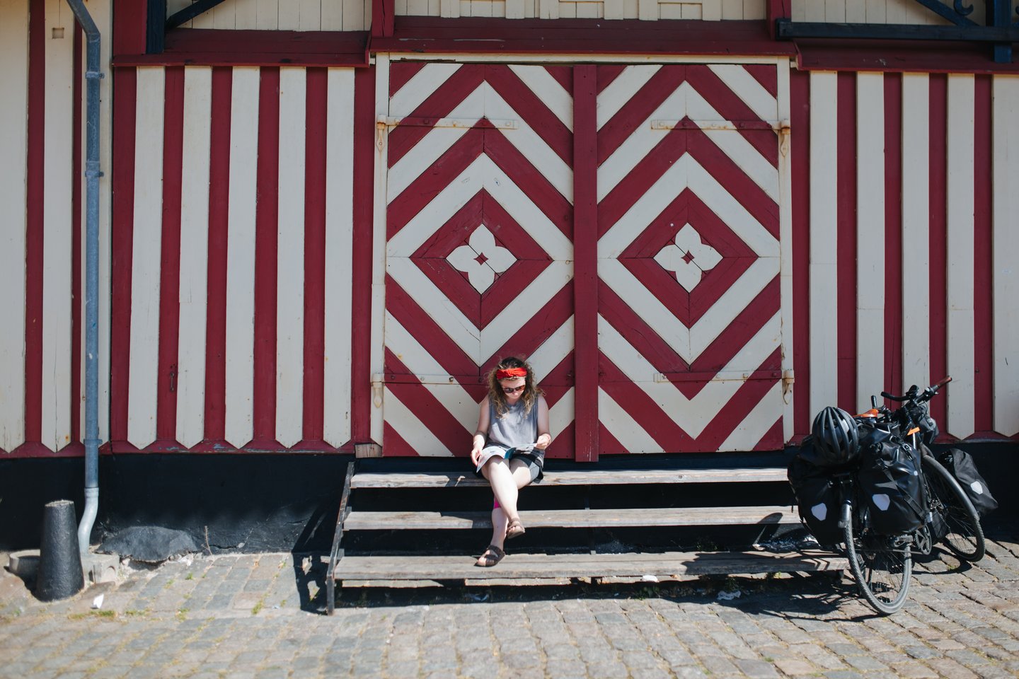 A woman sits reading a magazine on a sunny beach in Denmark