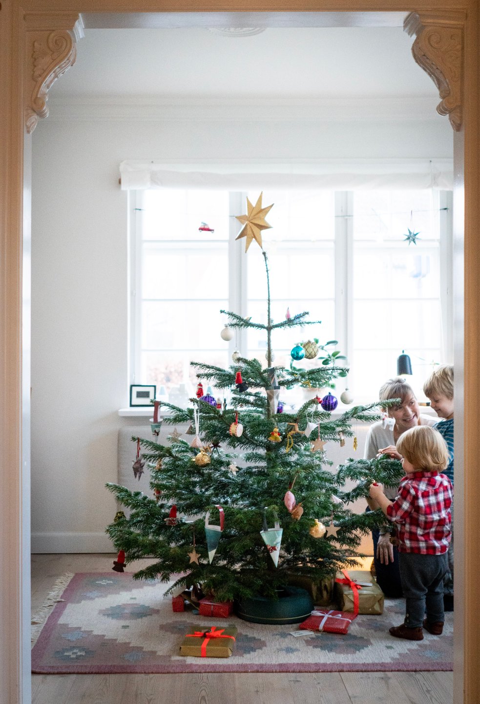 Familie dekoriert gemeinsam einen dänischen Weihnachtsbaum