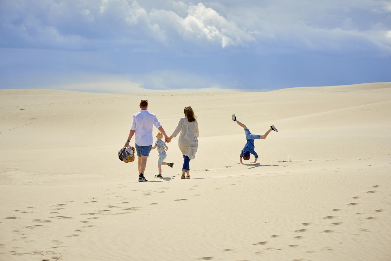 En familie som går gjennom Råbjerg Mile i Nordjylland