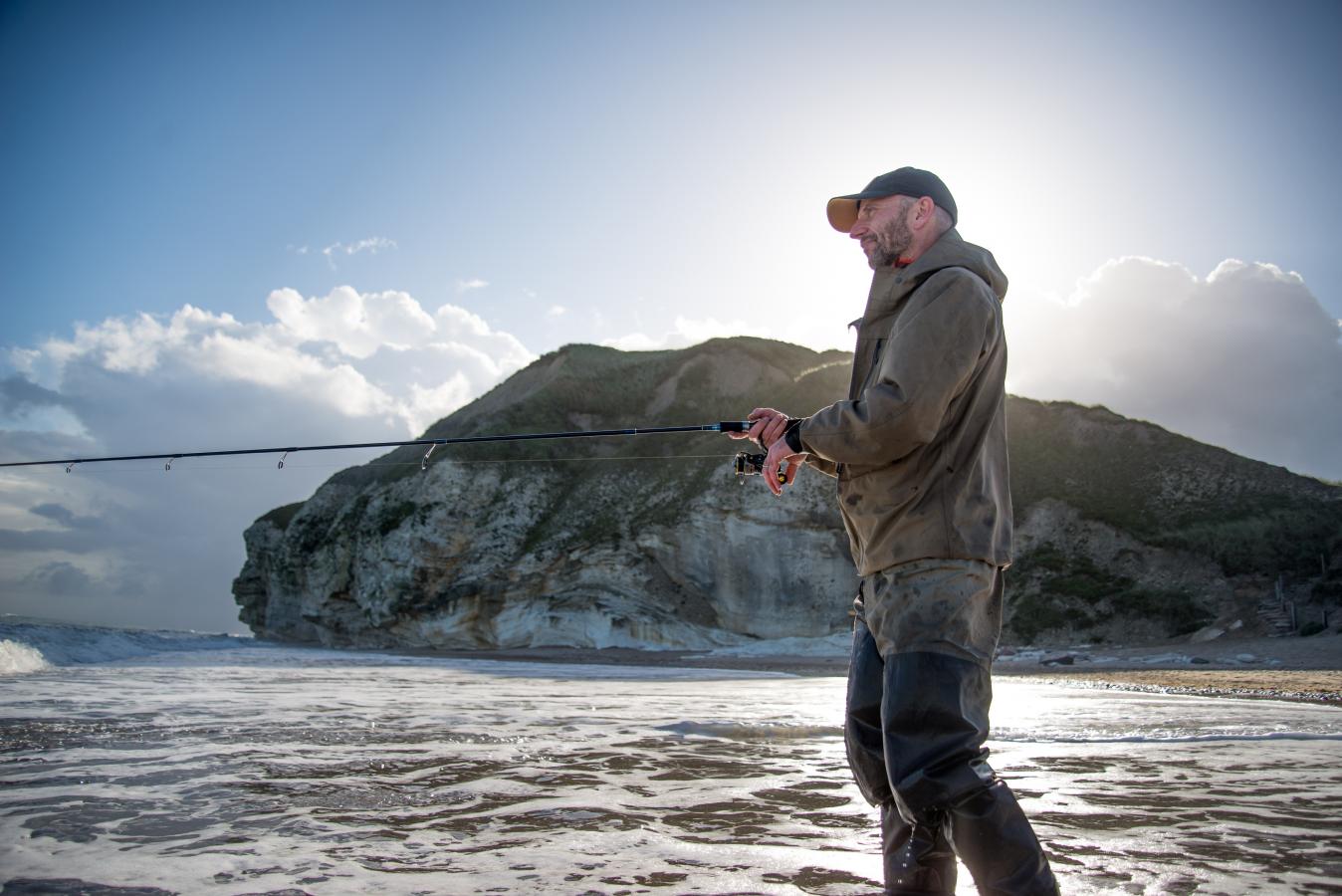 Angler steht im Wasser bei bei Møns Klint, Dänemark