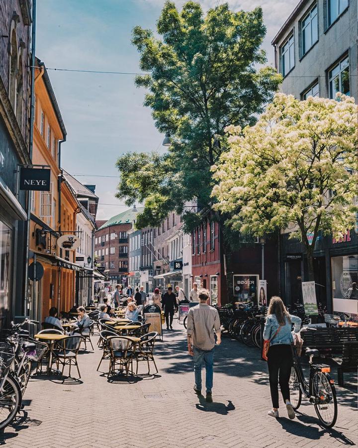 A couple stroll the streets of Odense in summer
