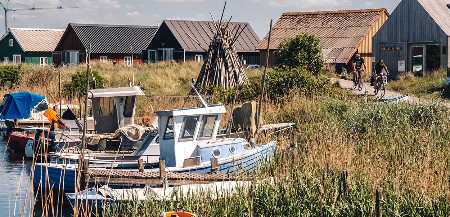 Ein Bild von dem Hafen "Tyskerhavnen" in Hvide Sande mit Fischerbooten und Häusern im Hintergrund