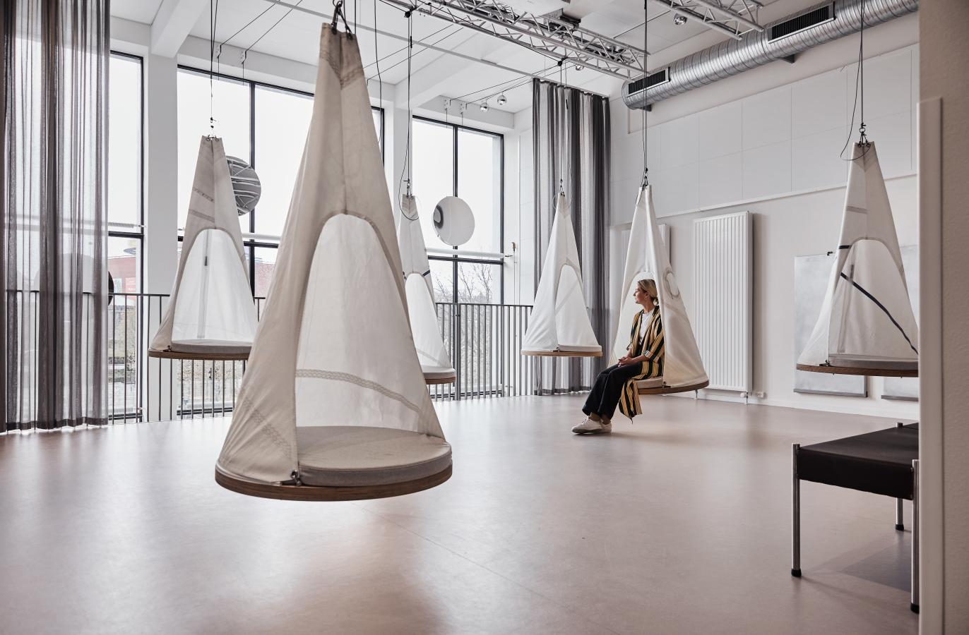 A woman relaxes in a hanging pod at Book1 design hostel in Aarhus, Denmark