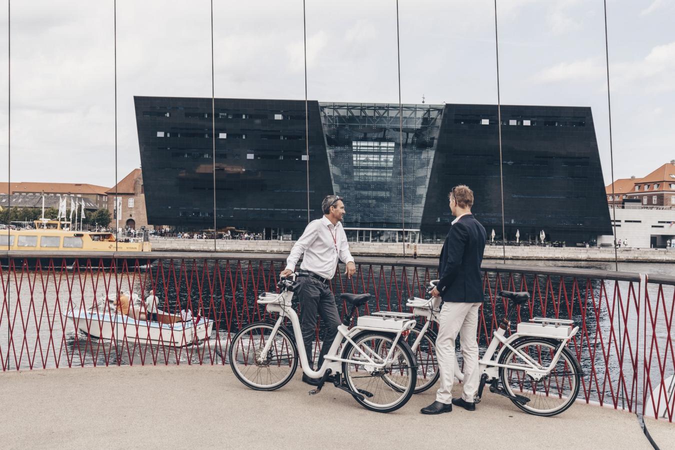 Business men with bikes talking on cirkelbroen in Copenhagen