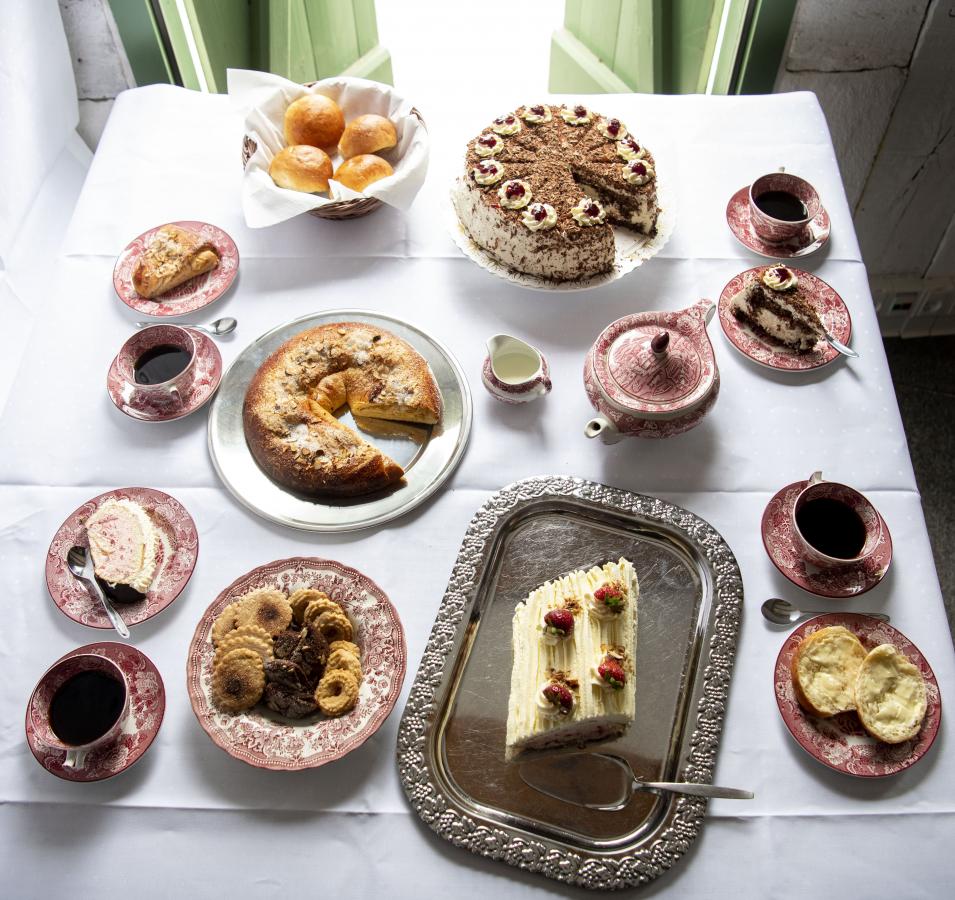 Kaffeetafeln, Bild eines Tisches mit Kuchen und Tassen mit Kaffee