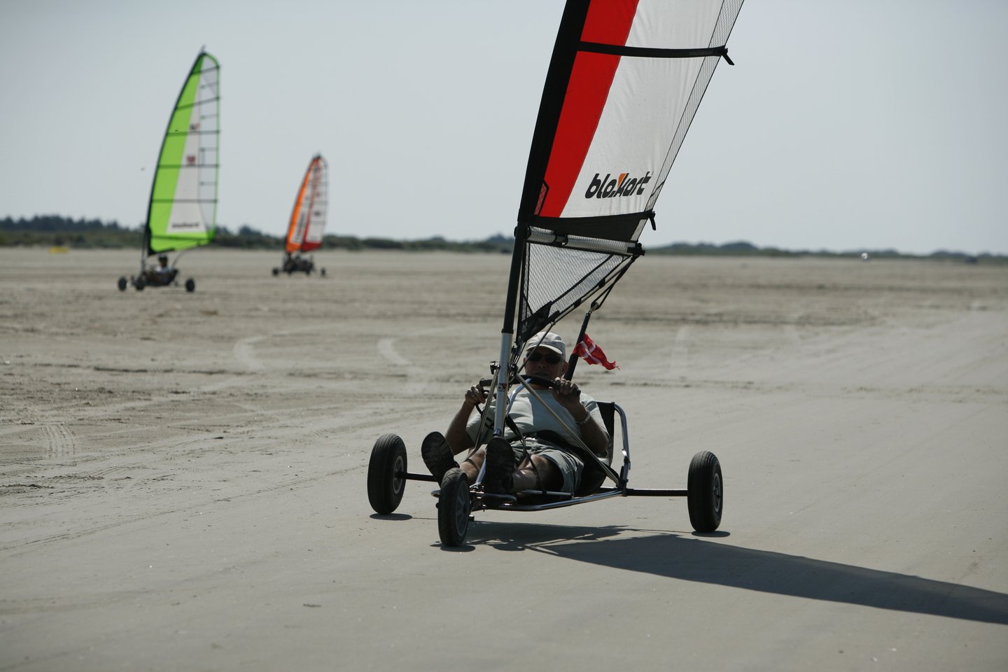 A man sits in a blokart on a beach in Fanø, an island in Denmark