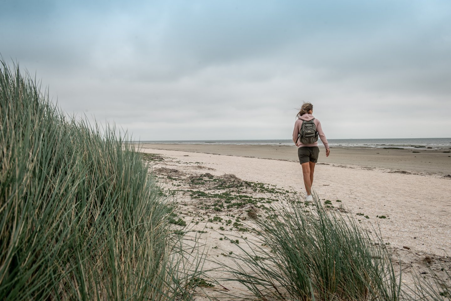 ung kvinne går tur langs stranden på Fanø