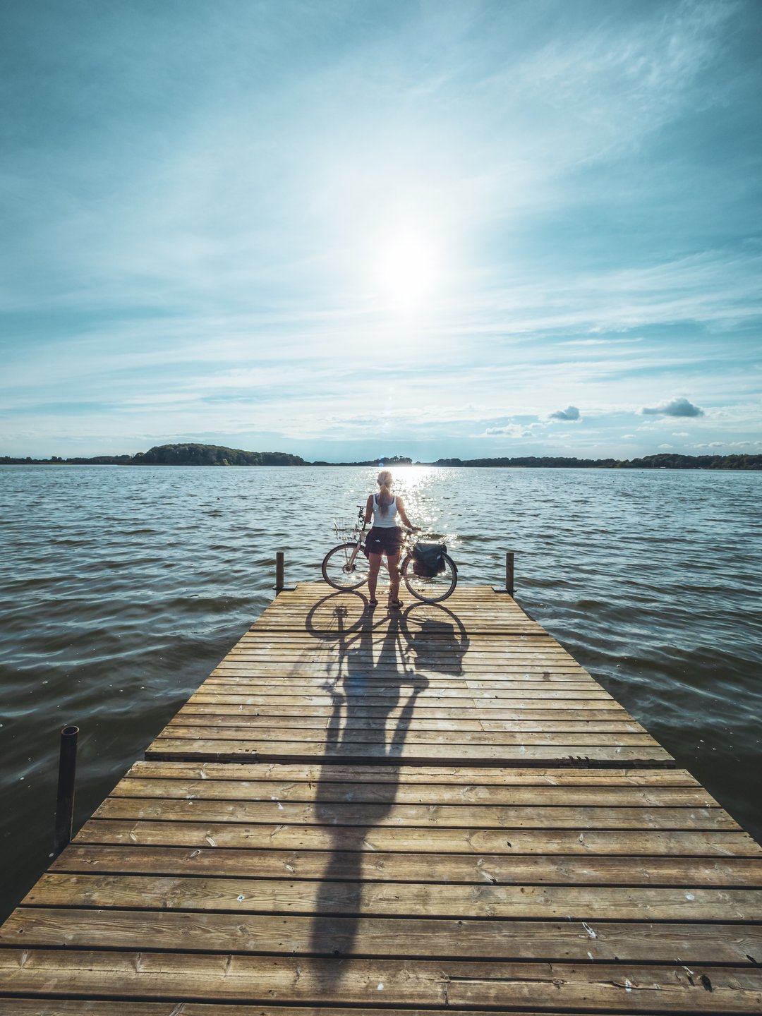 Cyclist standing at Soendersoe lake in Maribo, Lolland-Falster