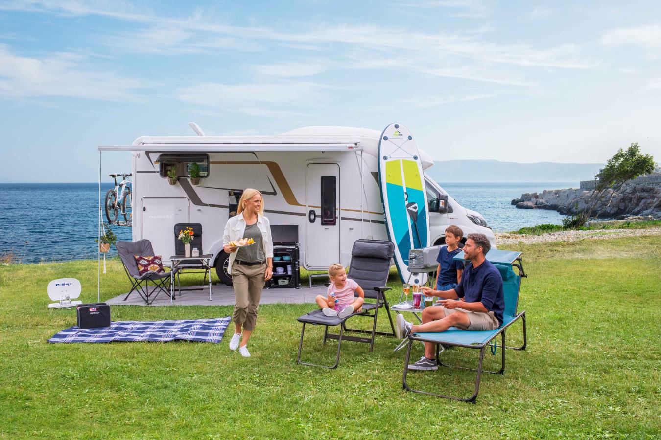 Familie sitzt vor Campingvan in Dänemark