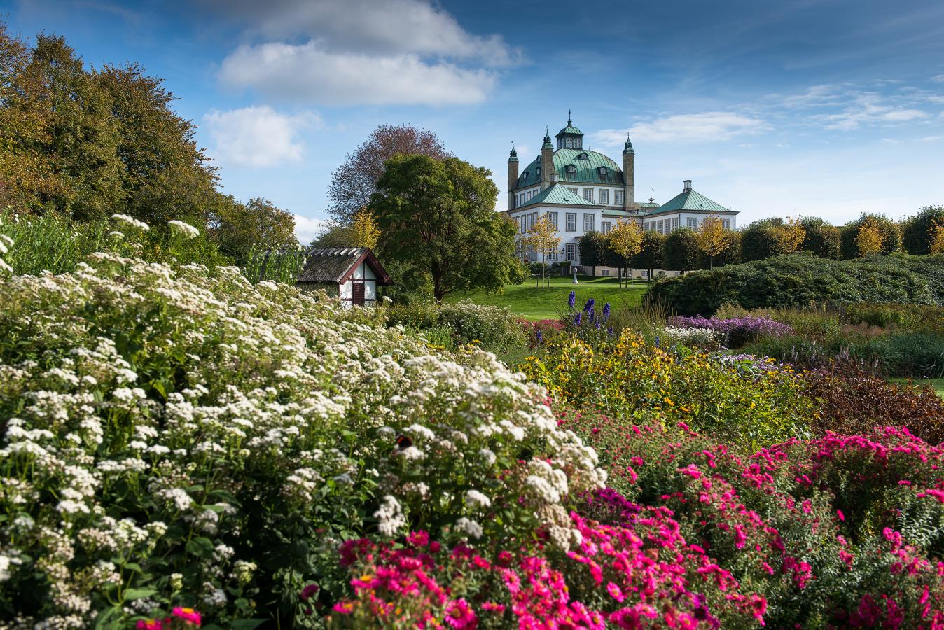 Fredensborg Schlossgarten mit Blumen im Vordergrund und dem Schloss im Hintergrund