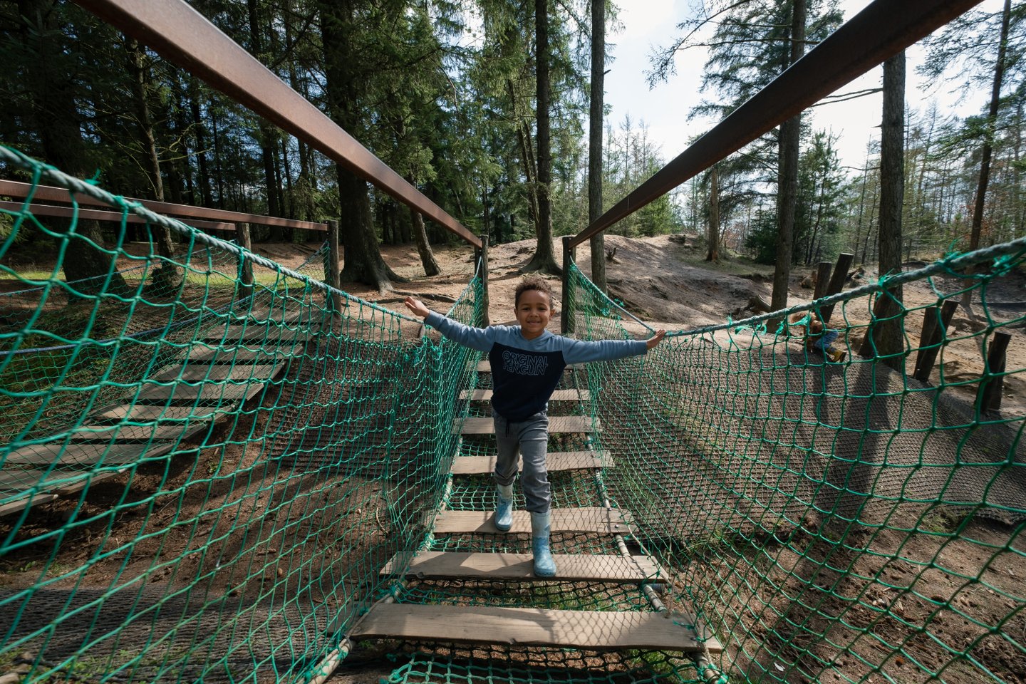 Boy playing on nature playground at Momhøje Naturcenter, Denmark