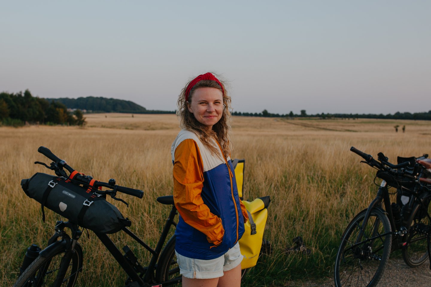 Woman with bikes on cycling trip at Naturparken Hindsgavl Dyrehave near Middelfart, Fyn