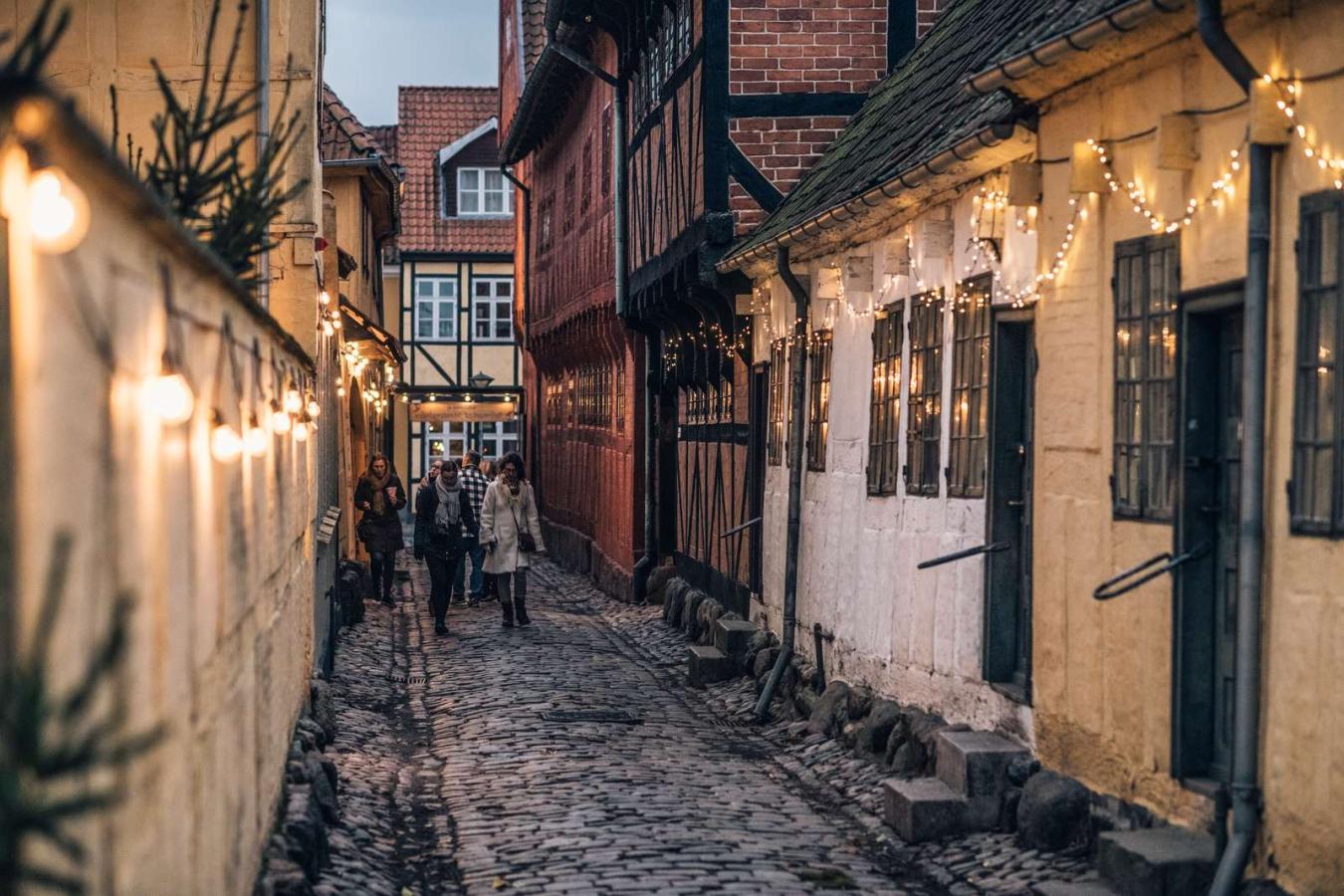 A cobbled street in Odense lit with Christmas lights