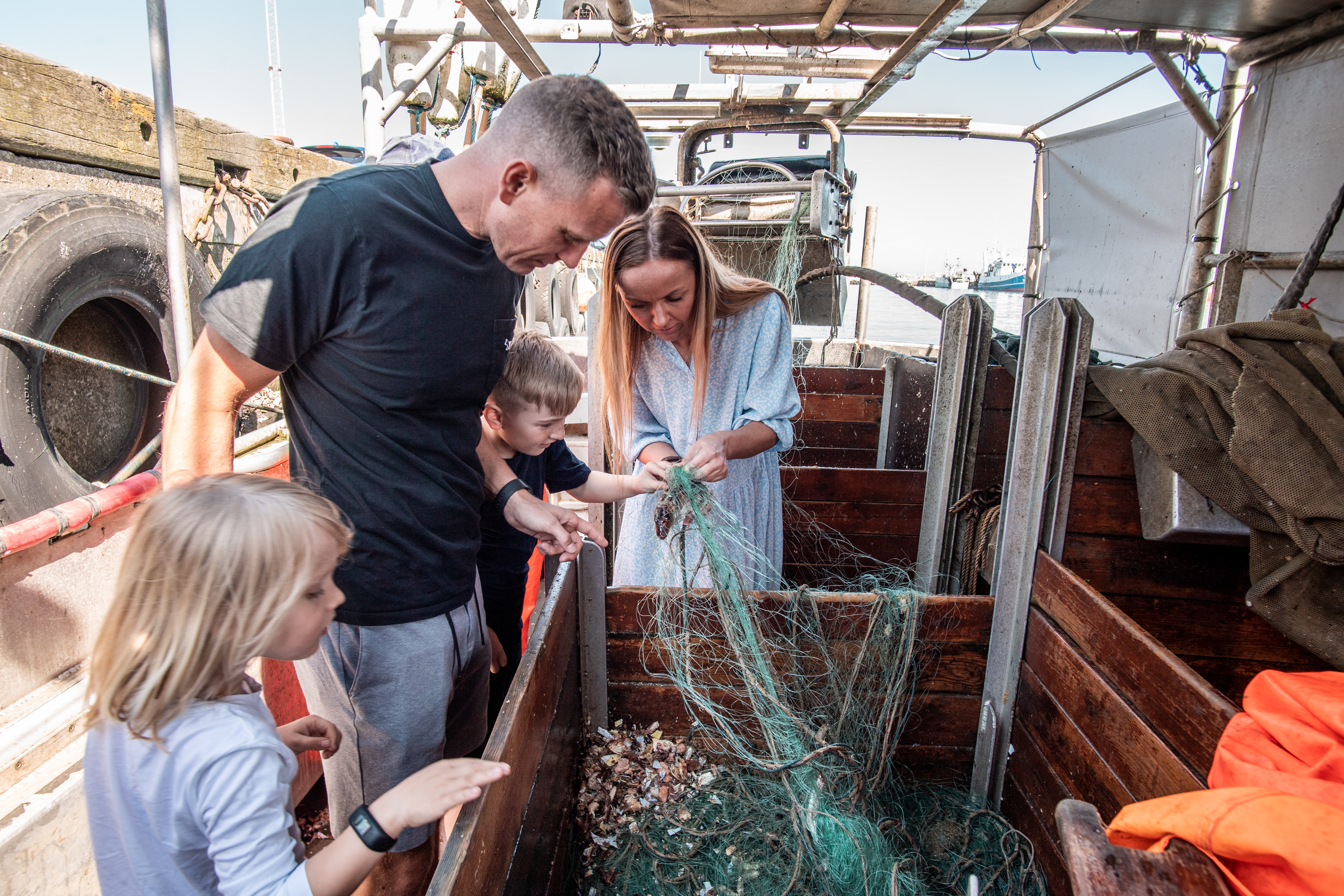 Picture of family at Hook & Cook wirh fresh fish in a fishing net