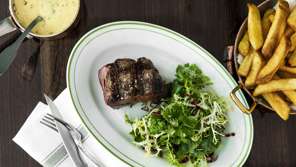 steak, frites og bernaise på et bord ved restaurant Les Trois Cochons i København