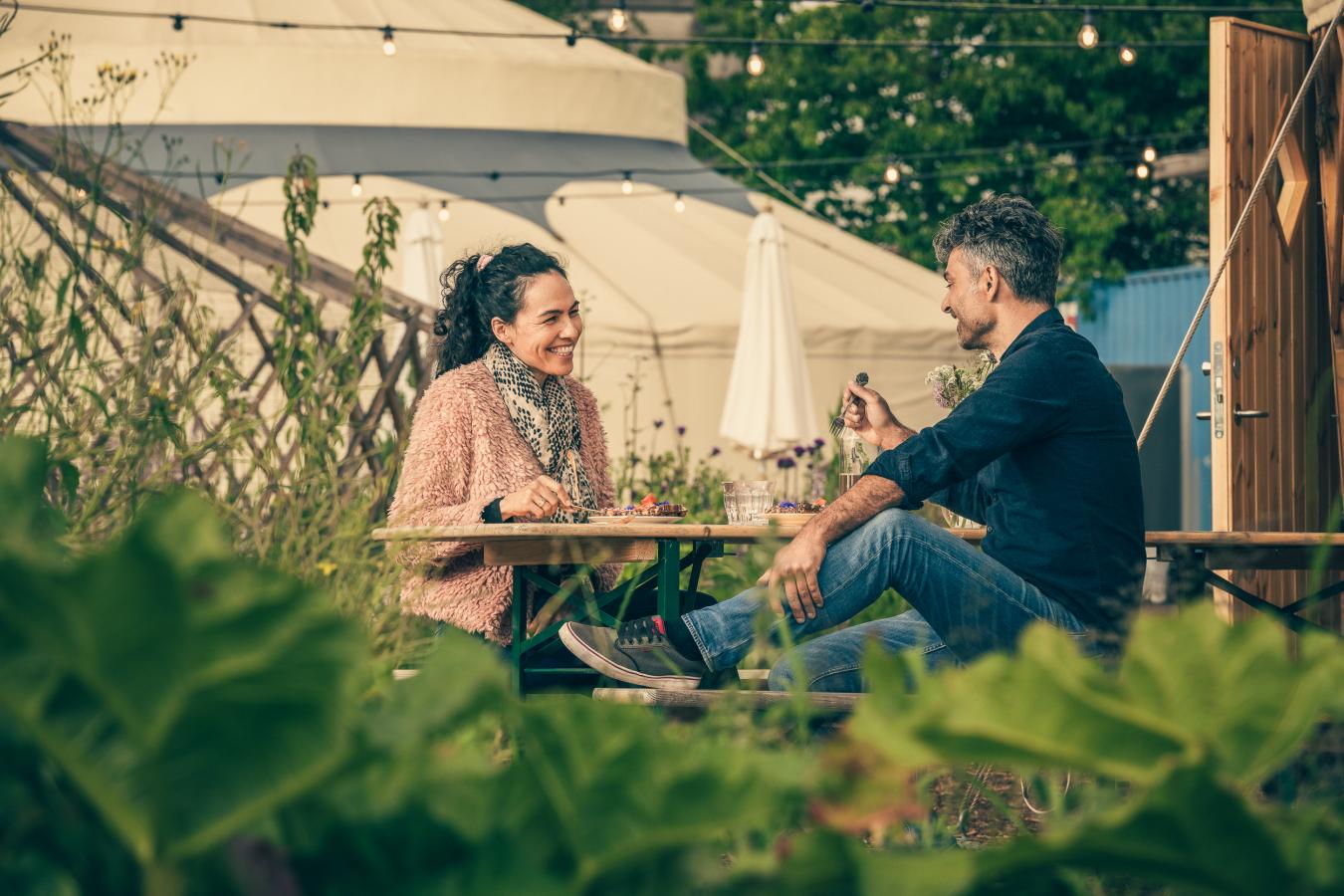Par sitter utenfor og spiser ved Øens Have i København