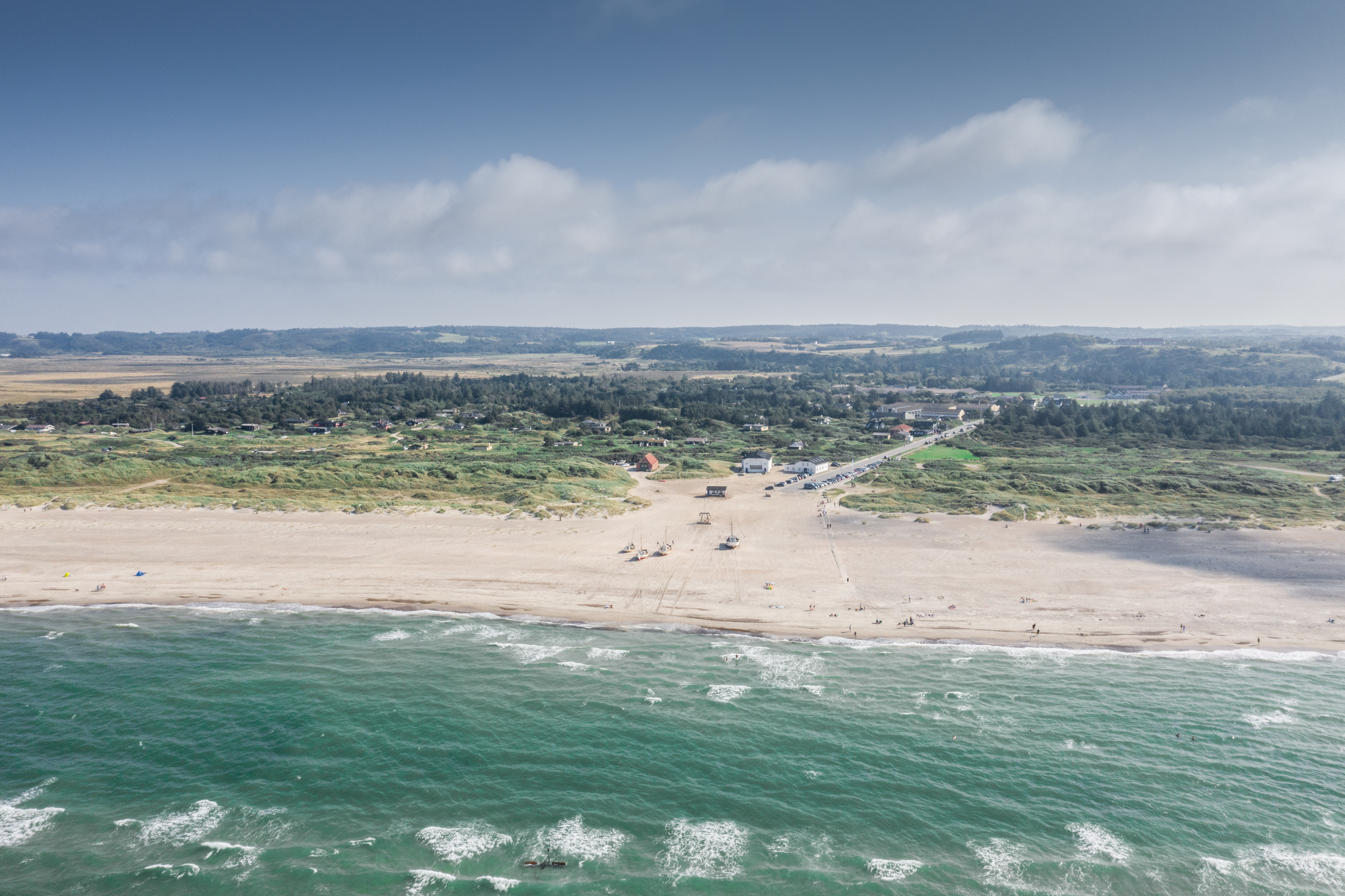 Ein Luftfoto von Slettestrand mit Fischerbooten am Strand