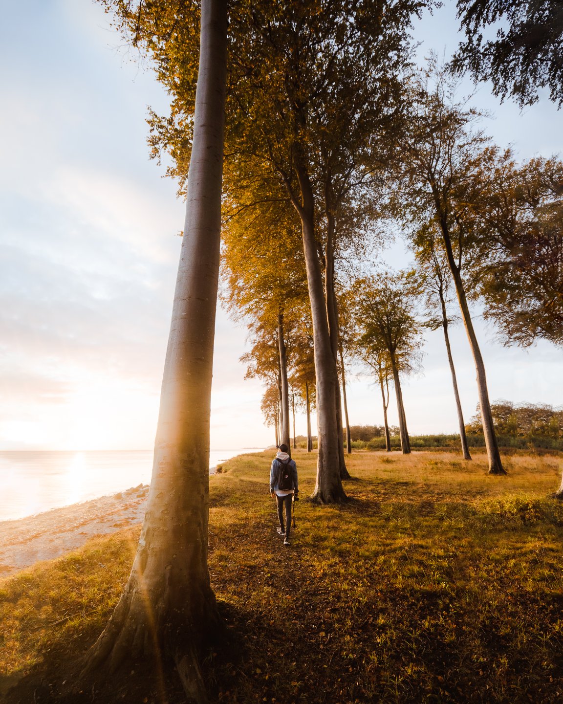 Een wandelaar in Denemarken kijkt uit op zee bij Flyvesandet op Funen