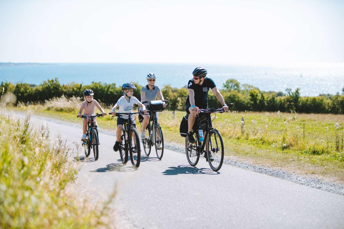 Familie sykler ved Skanserne ved Dybbøl Mølle i Sønderjylland, Danmark