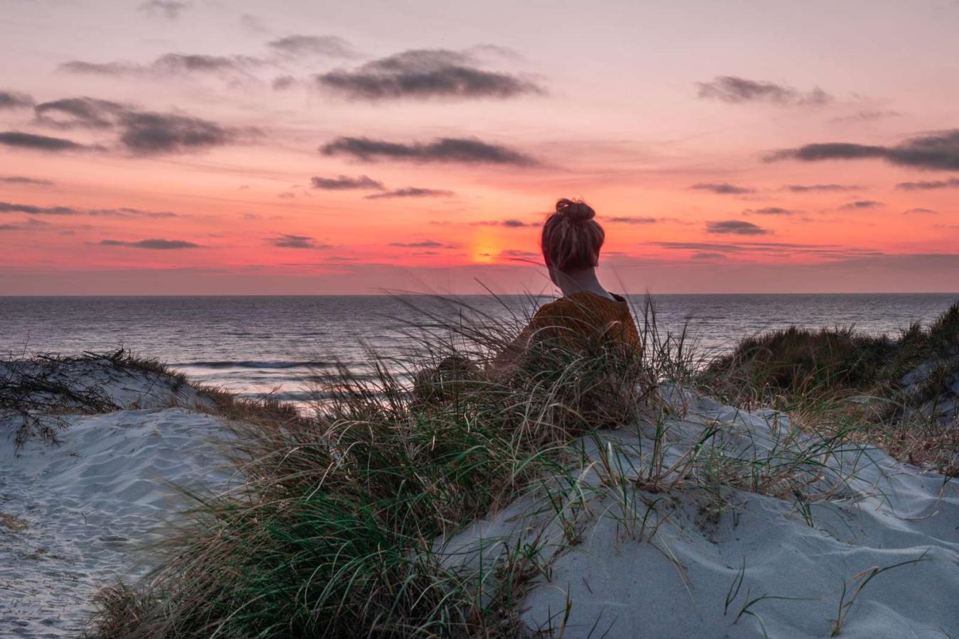 Woman watching the sunset on Søndervig beach, Vesterhavet