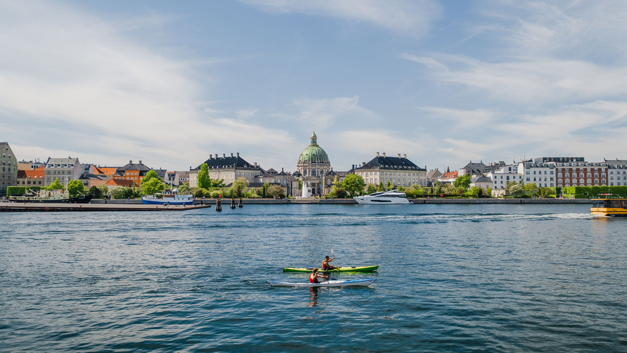Picture of a kayak on the sea with Copenhagen in the background
