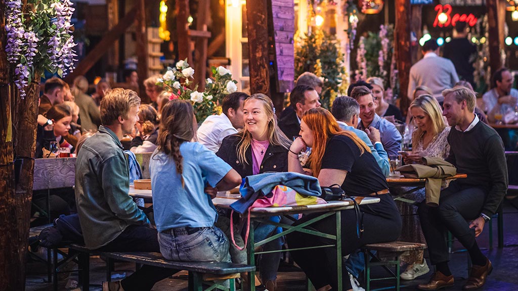 En gruppe venner ved et bord i Storms Pakhus, Odense Street Food marked, Danmark