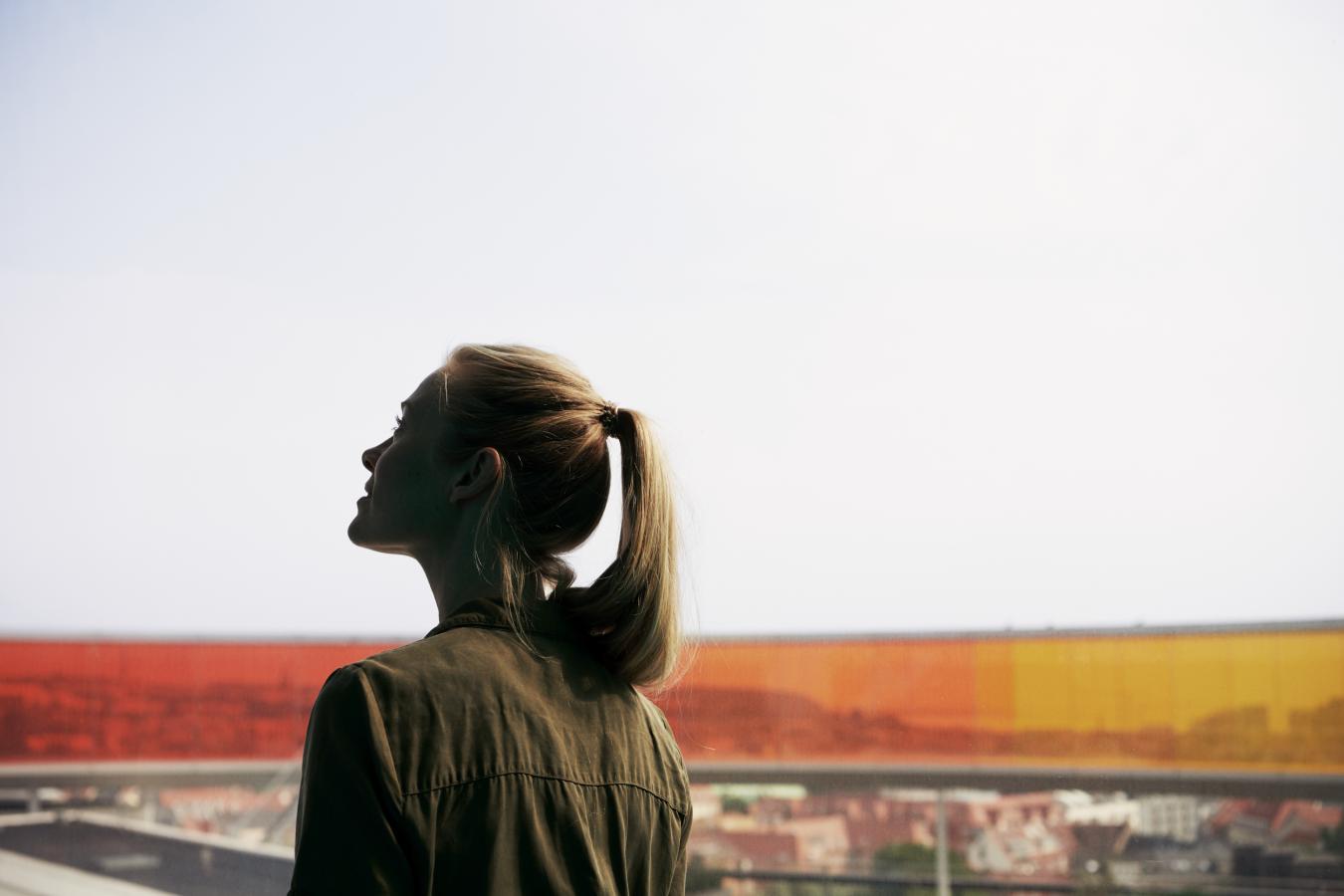 Kvinne ser på Your Rainbow Panorama ved ARoS i Aarhus, Danmark