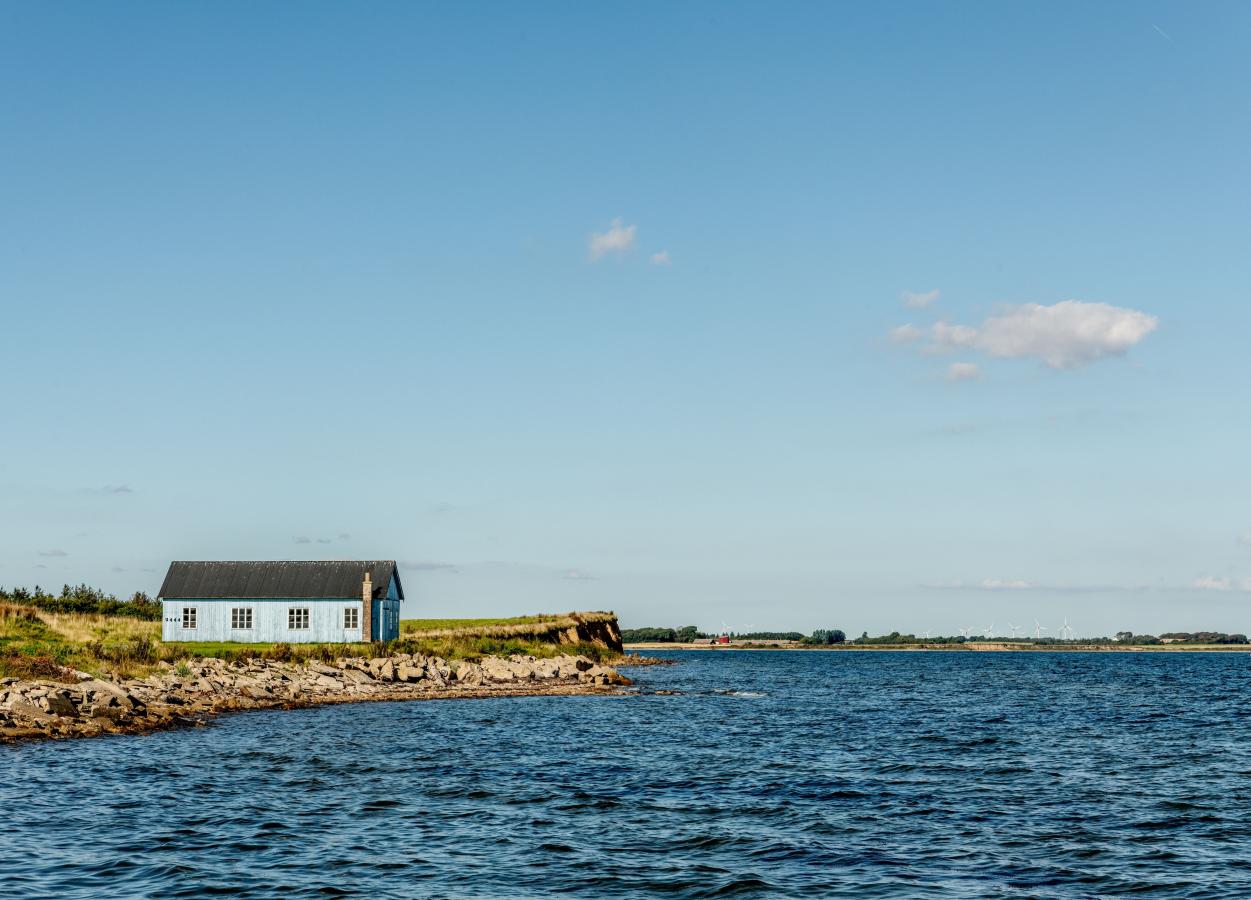 Et lite hus ved vannet på øya Jegindø i Limfjorden, Danmark