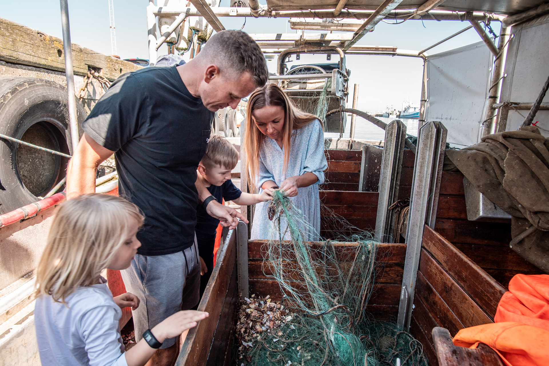 Bild von einer Familie auf den Kutter, die Muscheln sucht