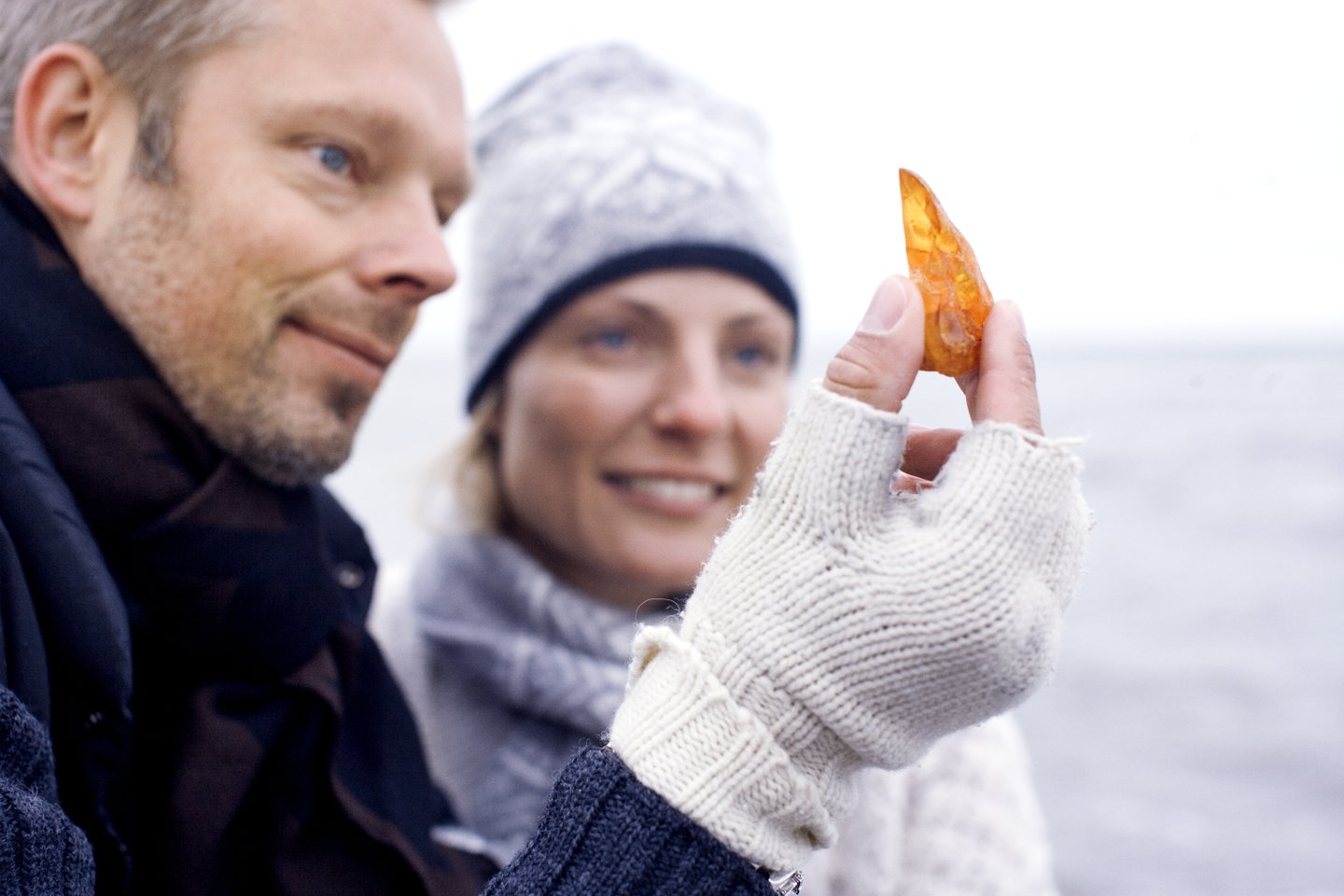 Een stel houdt gevonden amber omhoog op het strand in Denemarken