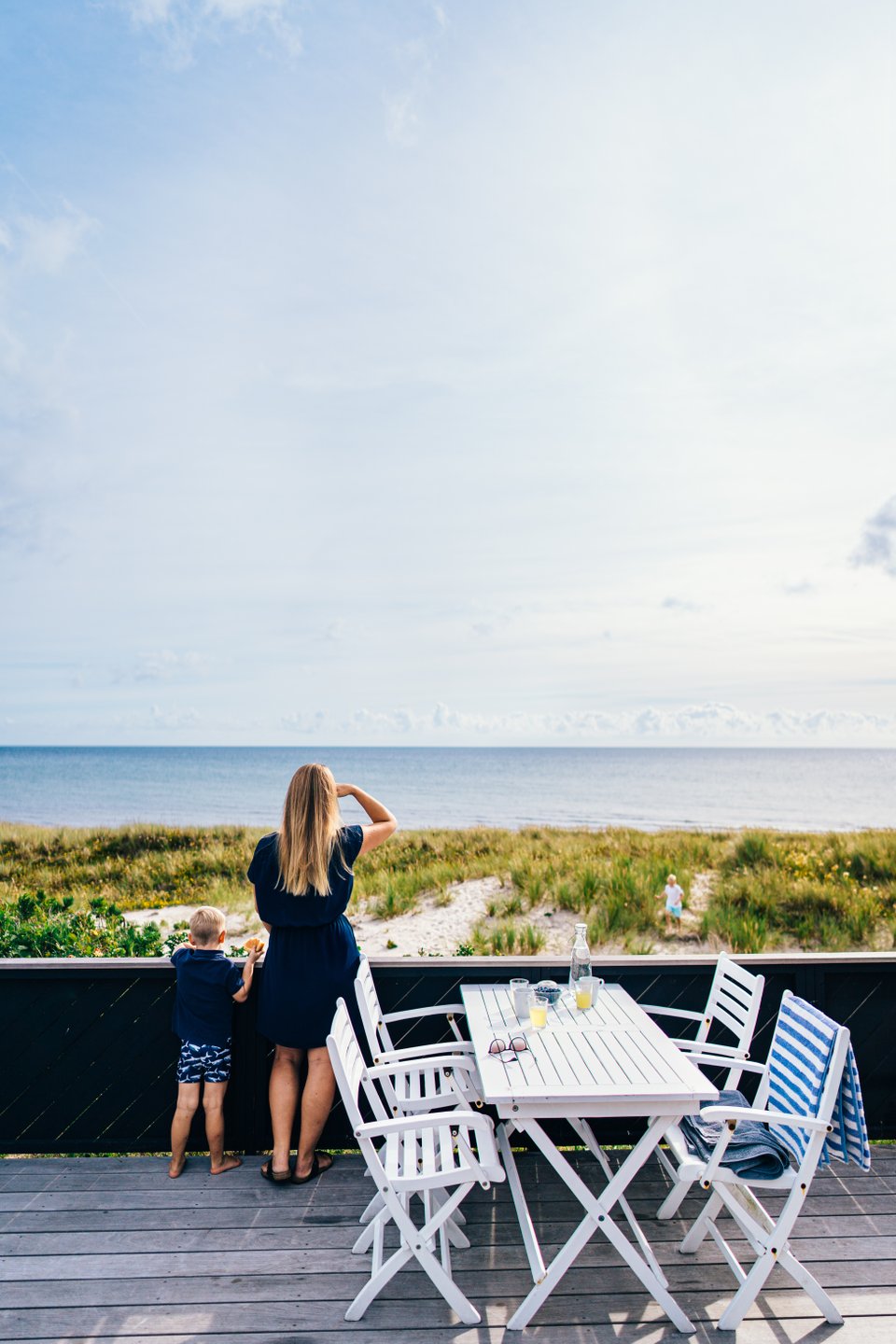 Mor og sønn speider utover Grenaa strand, fra sitt feriehus i Djursland, Aarhusregionen