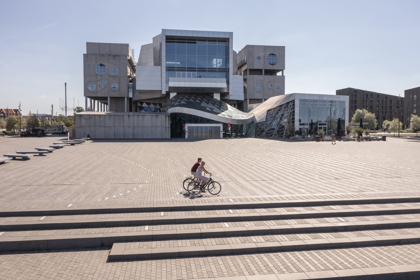 syklister passerer musikkens hus i Aalborg, Danmark