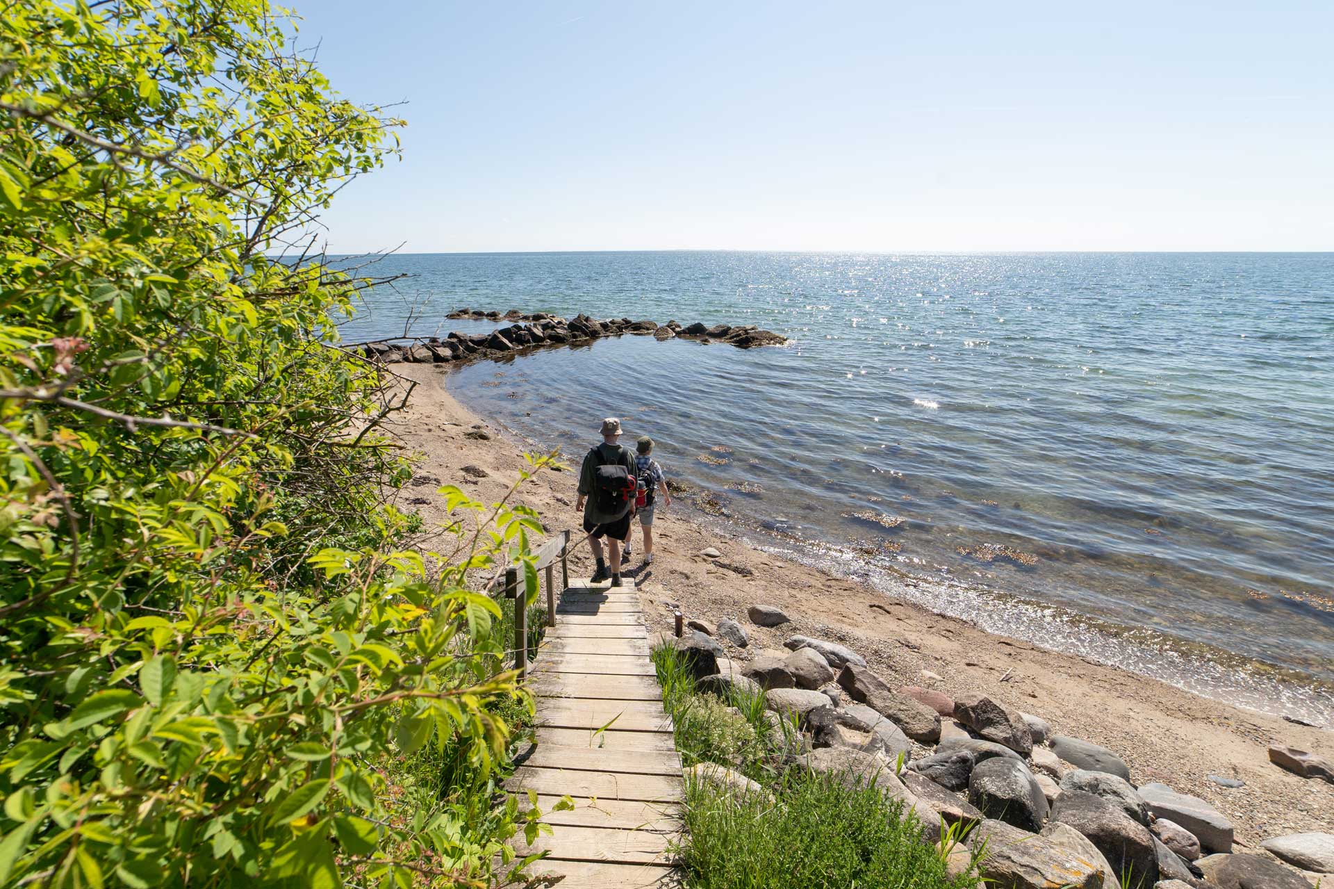 Ein Bild von zwei Personen, die am Strand wandern