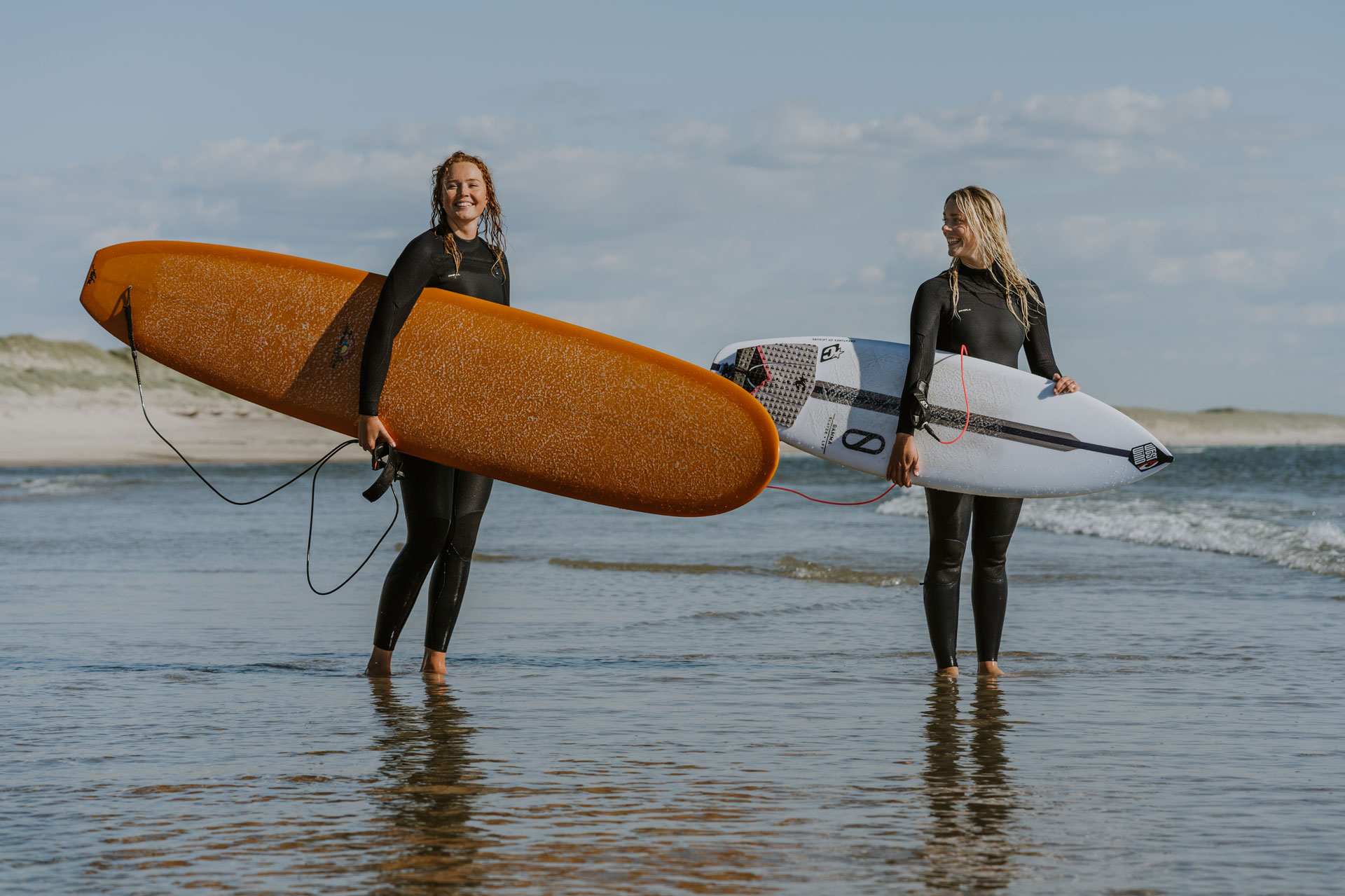 Zwei Surfer stehen im flachen Wasser an der Küste Dänemarks beim WATERZ-Wassersportfestivall.