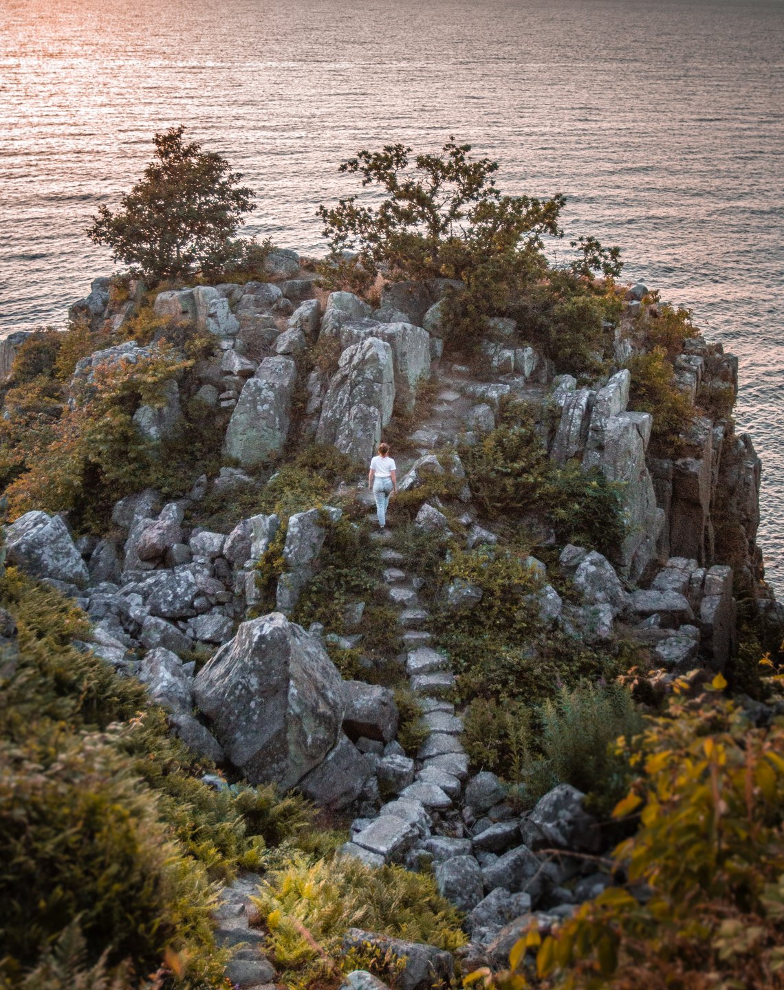 Een wandelaar beklimt de trap van Røverborgen op de Deense vakantiebestemming Bornholm