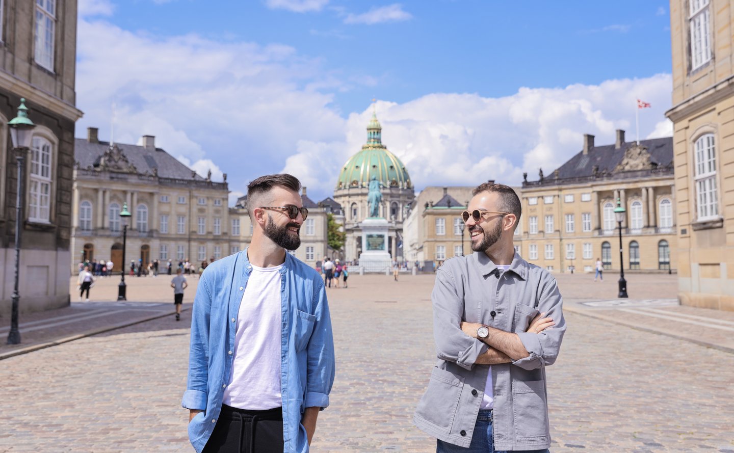 Reizigers verkennen Amalienborg in Kopenhagen, met op de achtergrond de mooie Marmorkirken