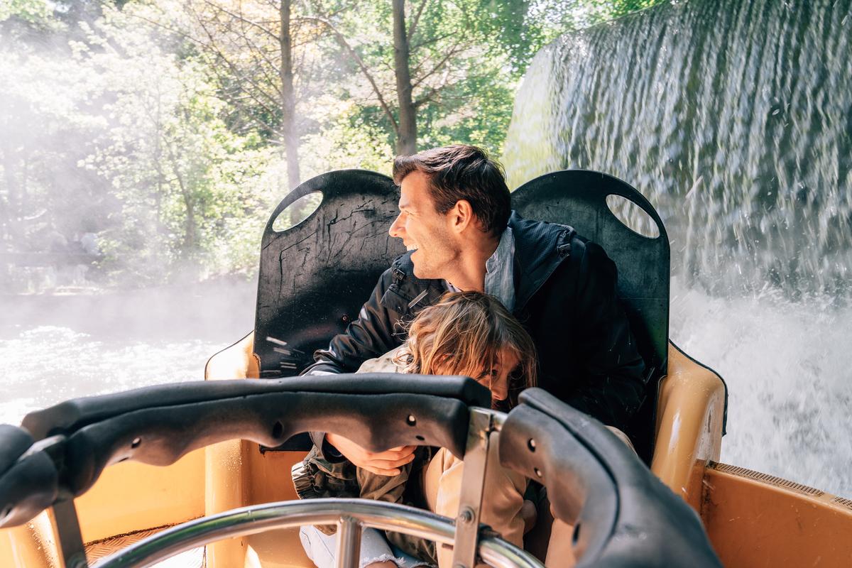 Far og sønn kjører en karusell på Fårup sommerland