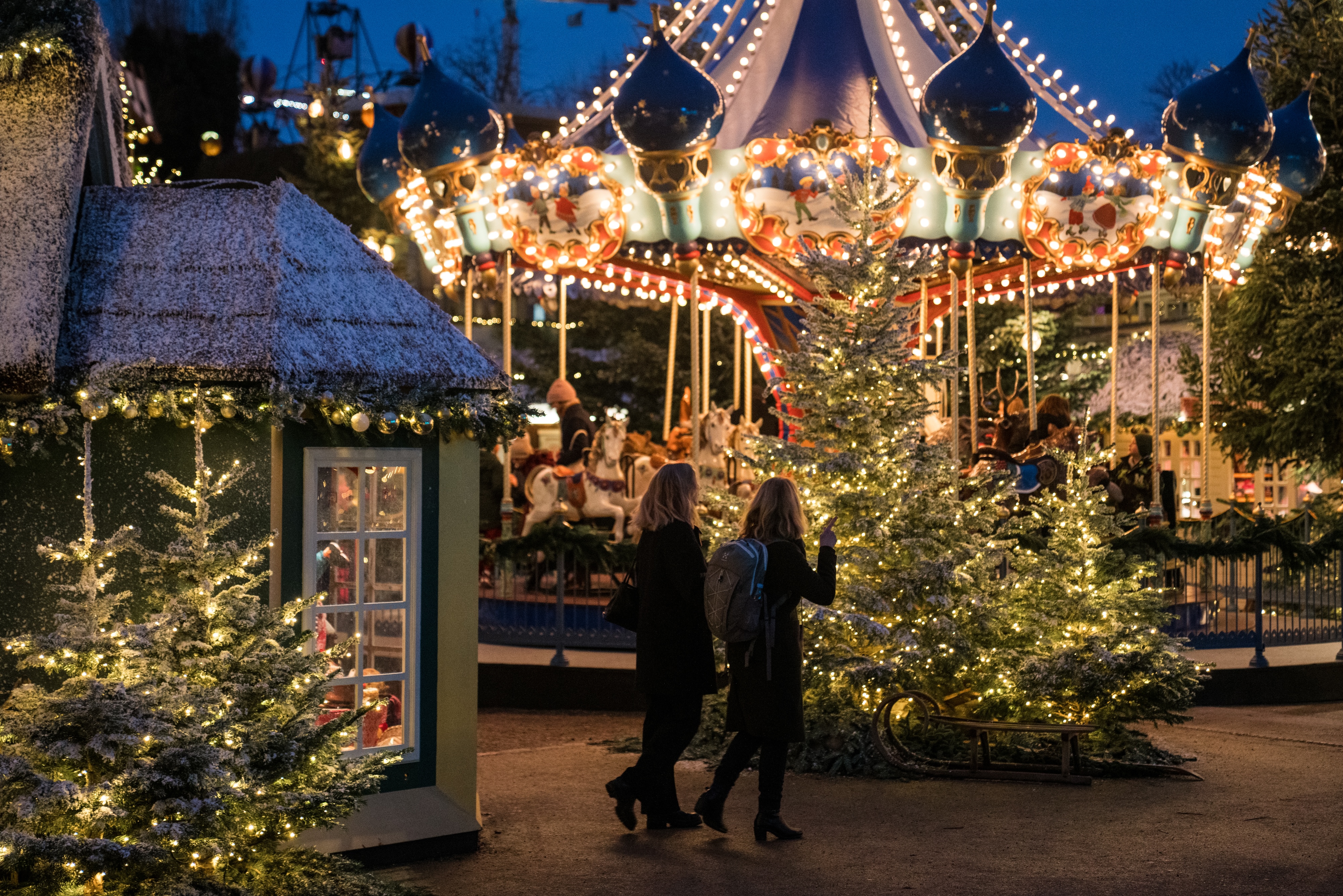 Julstämning på Tivoli. Bilden visar en gammeldags karusell med julgranar framför.