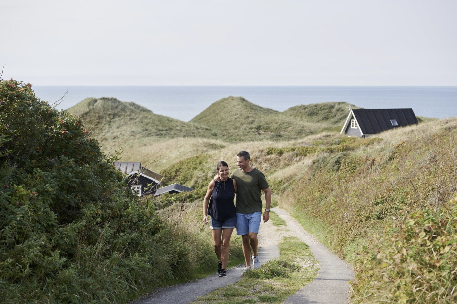 Een stel loopt langs een vakantiehuis in Hirtshals, Denemarken