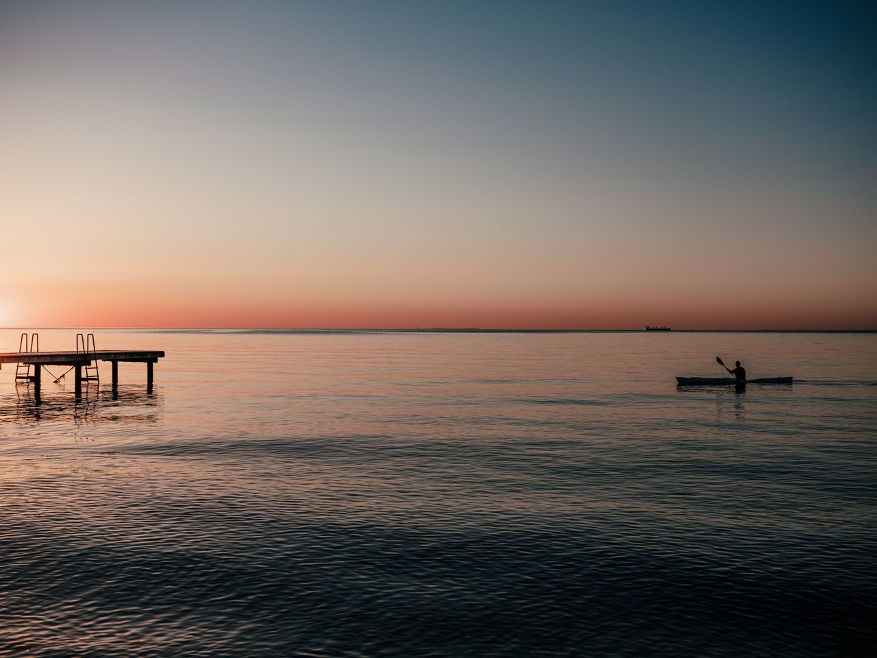 Een kajakker bereikt een pier in de Trekanten regio in Denemarken