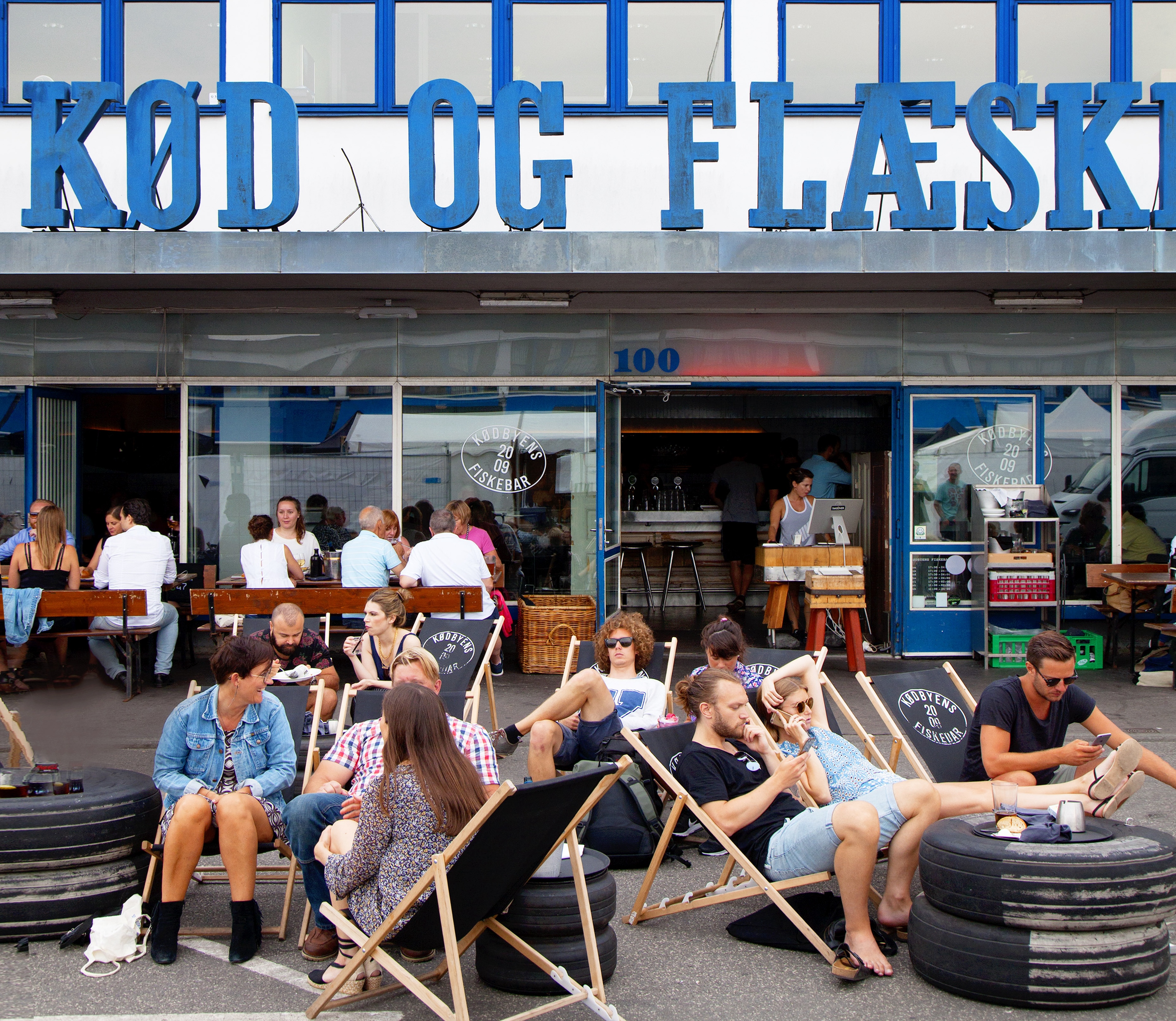 People sitting on sun chairs outside an old butchers building in the meatpacking district
