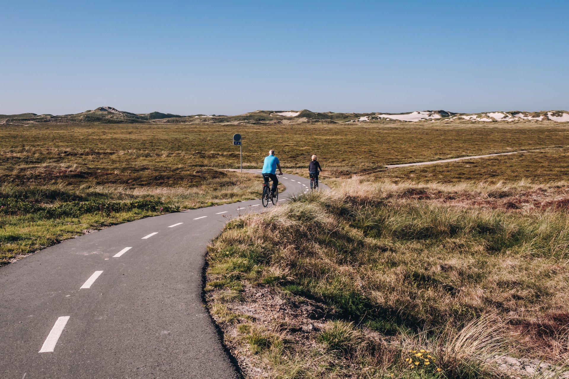 To personer, der cykler på en landevej i Hvide Sande